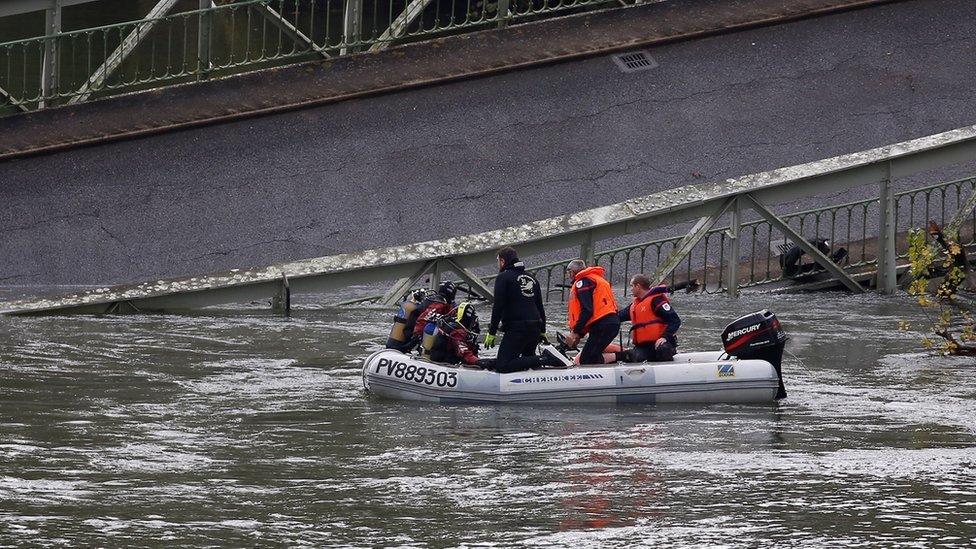 Rescuers at work to recover victims after a suspension bridge collapsed over the Tarn river