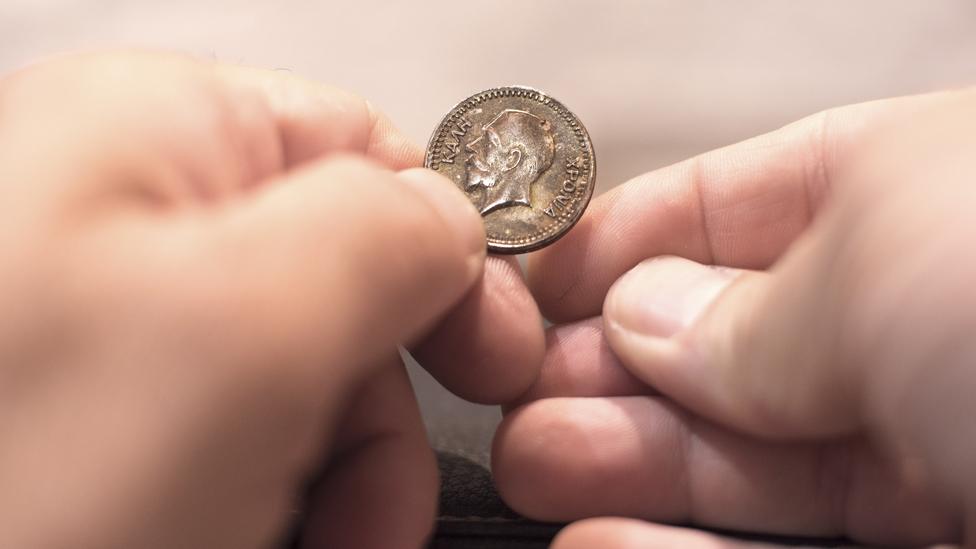 Coin held in fingers