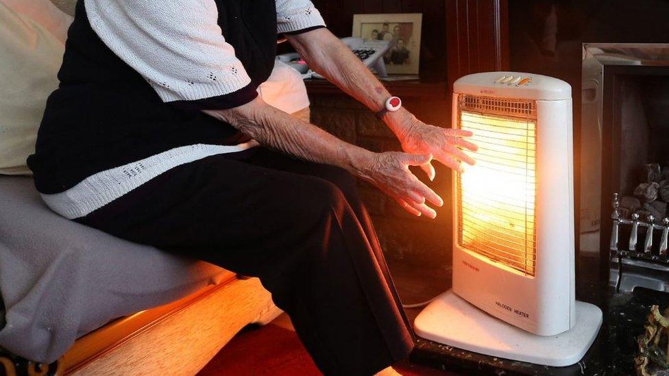 An elderly lady with her electric fire on at home,