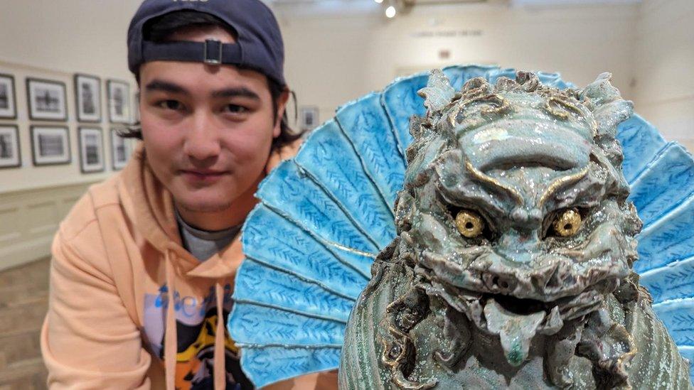 Jacob Chan poses with his artwork of a foo dog