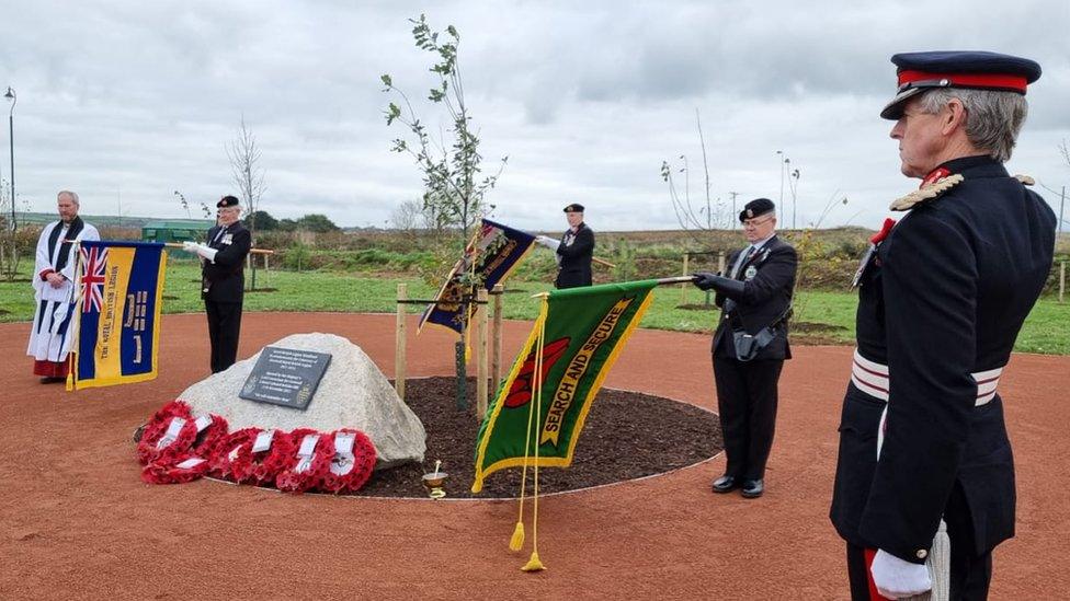 Wreaths and pallbearers at the opening of the wood