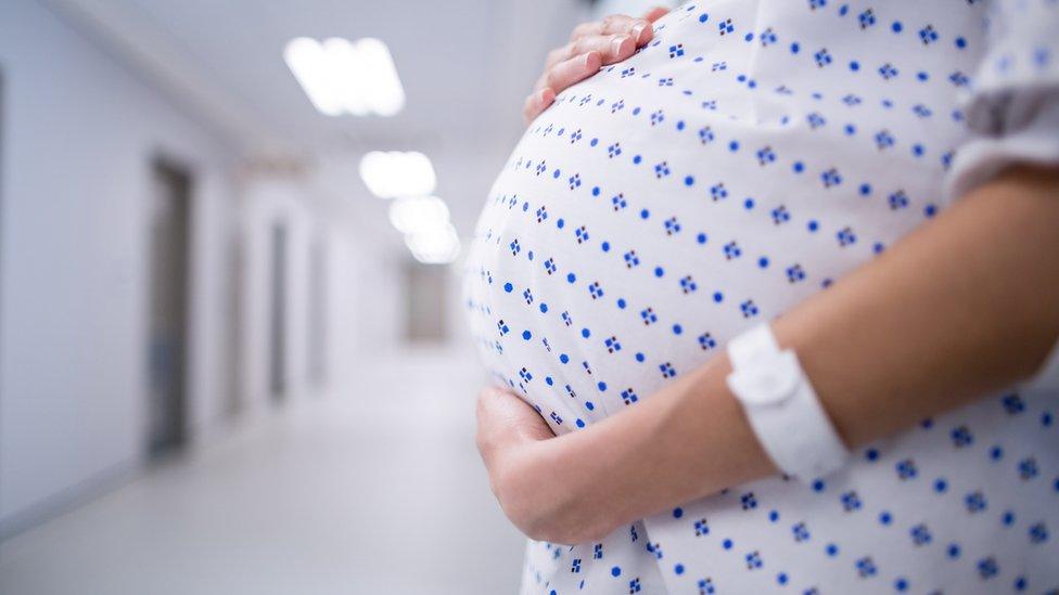 An image of an unidentified pregnant woman in a hospital gown