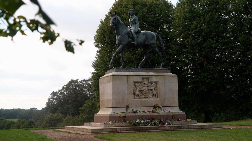 Statue on a plinth of the Queen riding a horse