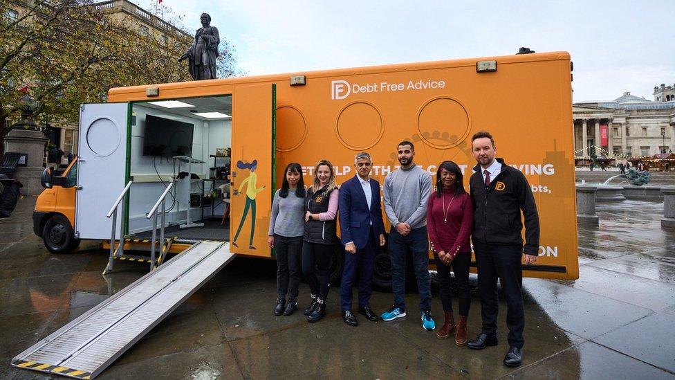 Sadiq Khan and Debt Free Advice staff in front of bus