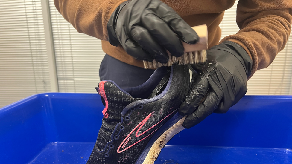 Close up of Liam Wood brushing a shoe during the restoration process