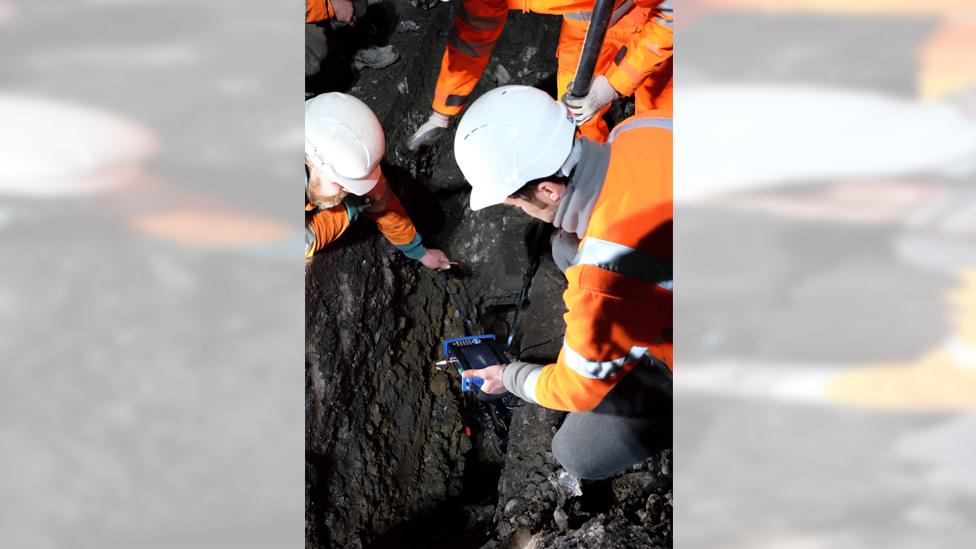 workers measure size of hole