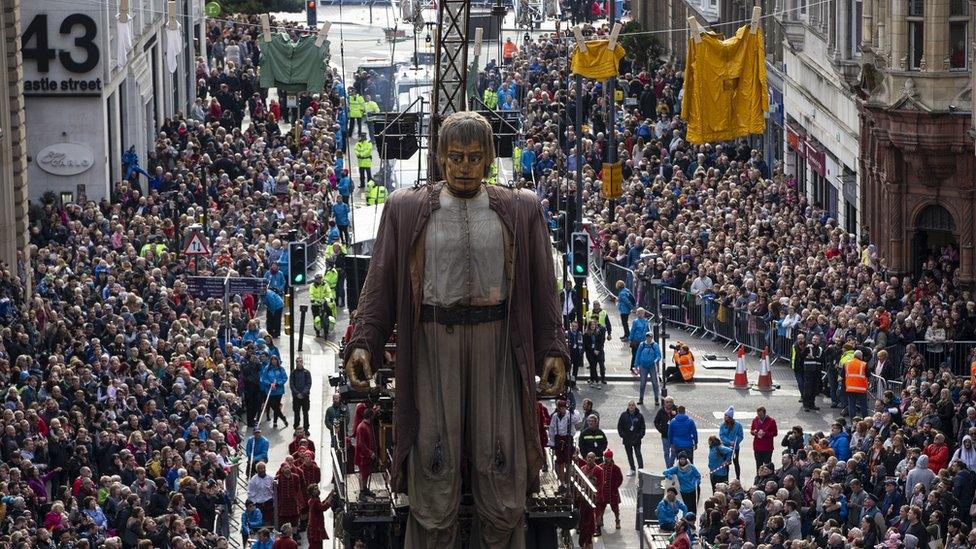 Hundreds watch "Giants" street puppet, The Giant Man, during a street theatre performance in Liverpool