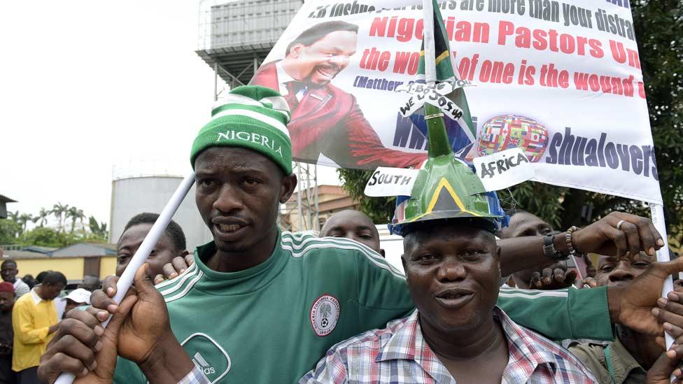 Supporters of TB Joshua carry banners in support of the preacher as they arrive for the ruling of the coroner's inquest on the collapsed guesthouse of Joshua's Synagogue Church of All Nations at the Lagos High Court, on 8 July 2015