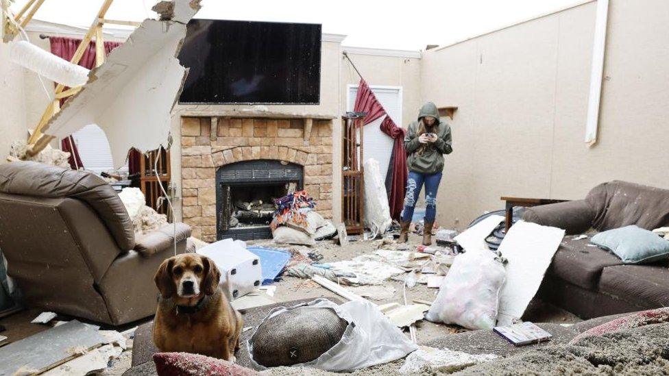 Members of the Littleton family examine the remains of their house following a tornado