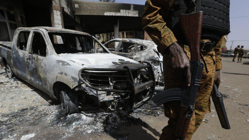 A soldier in Burkina Faso stands guard in the aftermath of an Islamist attacks