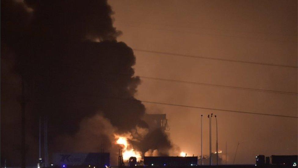 Smoke and fire erupt into the night sky after an explosion in the Binhai New Area in Tianjin Municipality