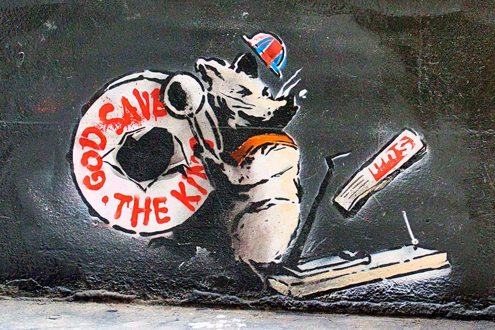 Street art of rat playing drum