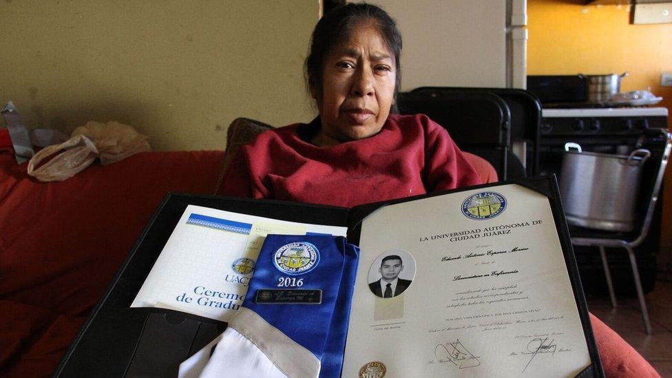 Patricia Moreno holds her son's nursing diploma in her hands.