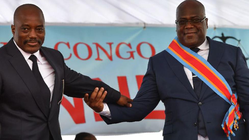 Democratic Republic of the Congo's newly inaugurated President Felix Tshisekedi (R) walks off the podium with outgoing President Joseph Kabila