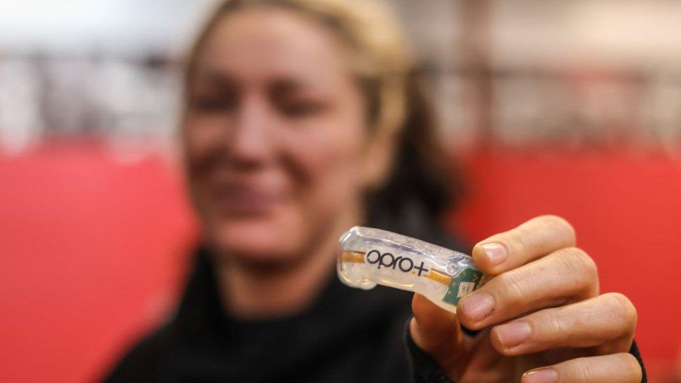 woman holding smart mouth guard