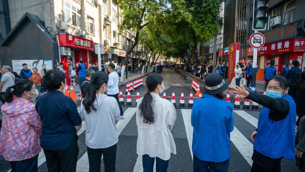 Volunteers form a line to block the BBC crew