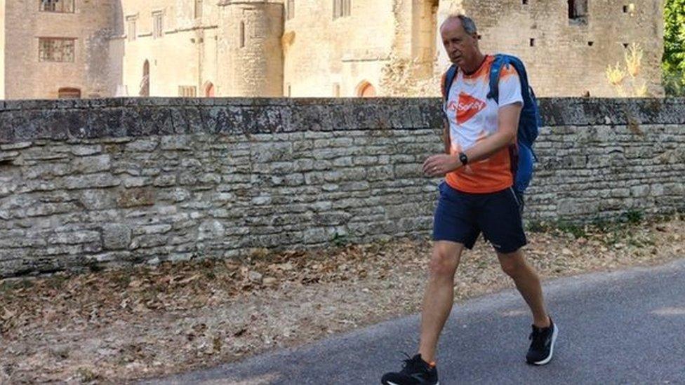 Stuart Dawson walking in front of a historic building