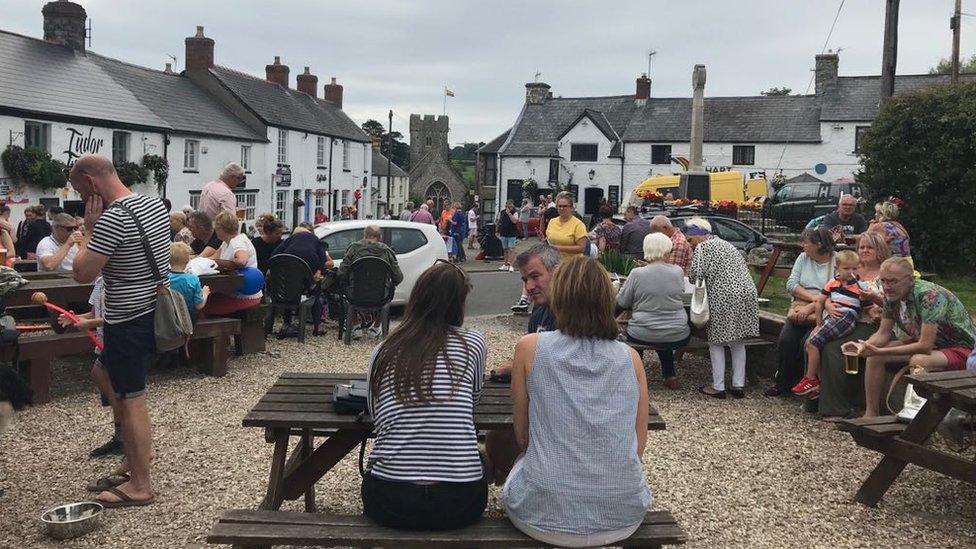 People gathered on pub benches