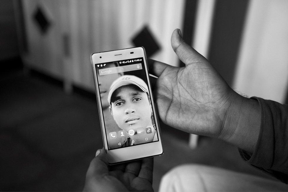 A family member holding Sagar Shejwal’s photo.