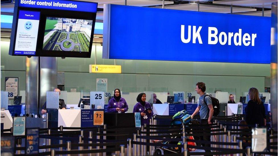 Travellers at passport control at Heathrow Airport