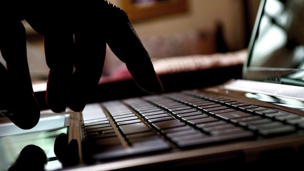 fingers hovering over a computer keyboard