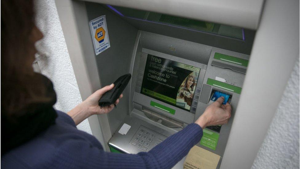 Woman using cash machine