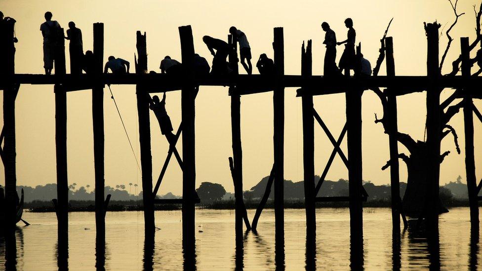 Silhouette of people on a bridge