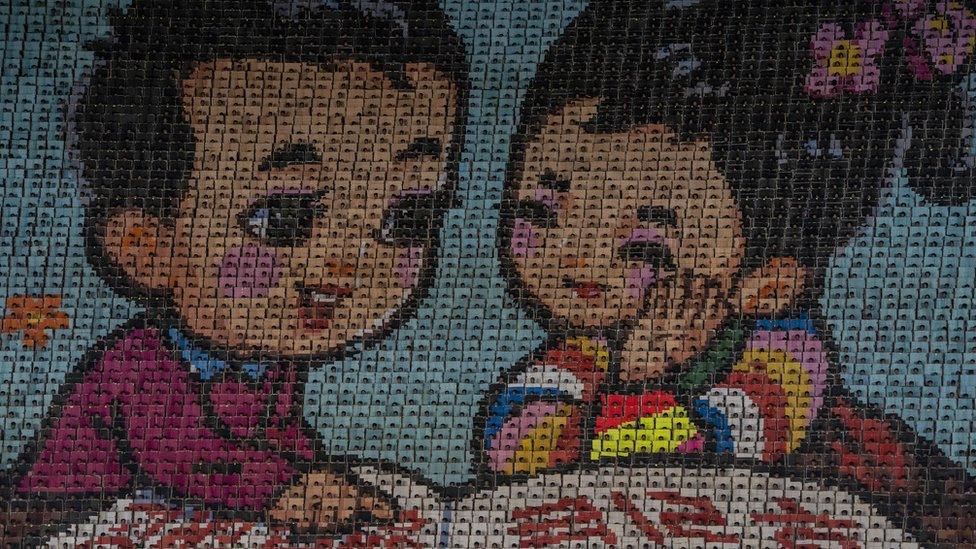 A 'moving image' wall of 17,490 schoolchildren creating a mosaic of a boy and a girl