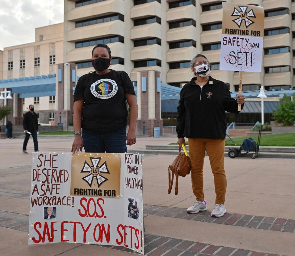 Vigil for Halyna Hutchins with people holding up placards calling for "safety on set"