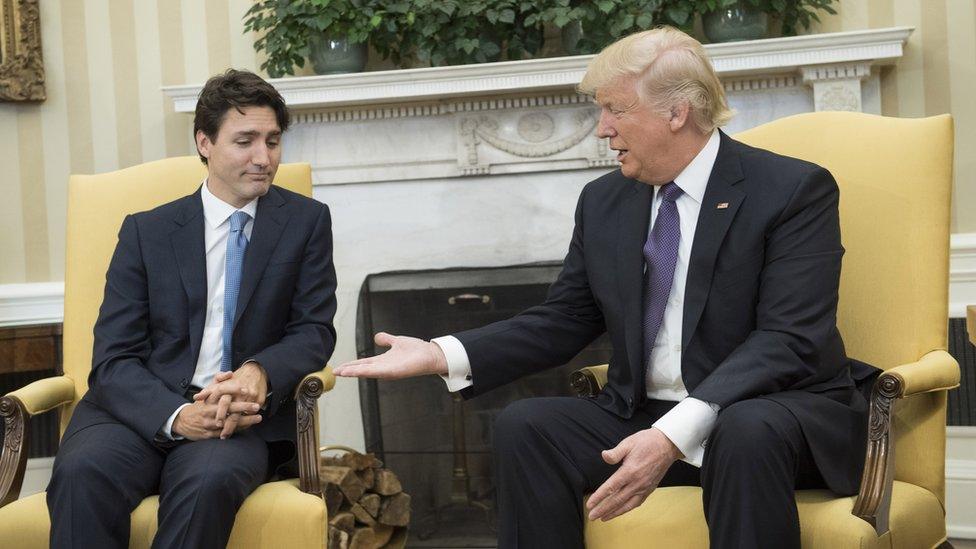 US President Donald Trump extends his hand to Prime Minister Justin Trudeau of Canada during a meeting in the Oval Office