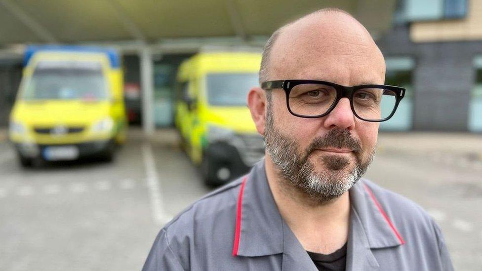 Nurse in front of two ambulances