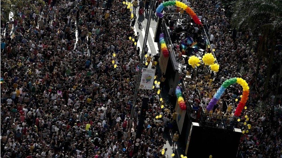 Crowds throng around a bus at Sao Paulo's Gay Pride Parade