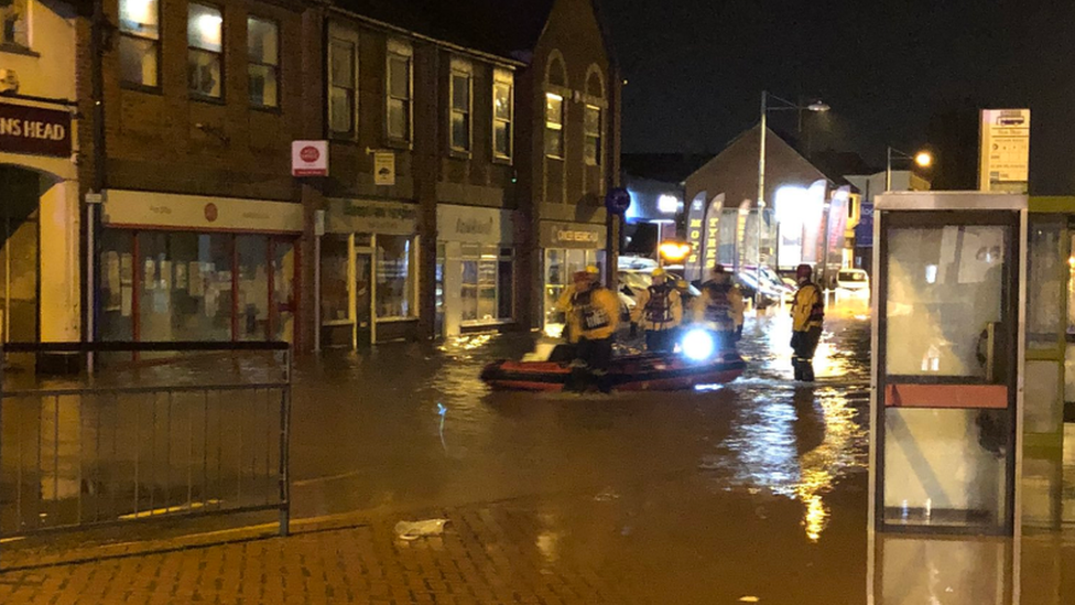 Firefighters on boat in flooded town centre