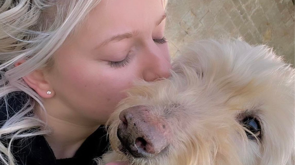 Jaz Davies kissing a dog