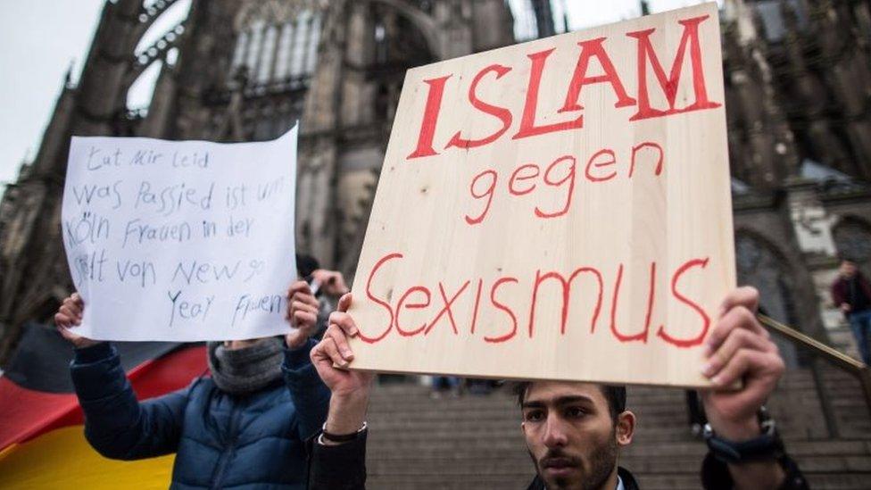 A man from Syria carries a sign that reads "Islam against sexism" in front of the central railway station in Cologne (10 January 2016)