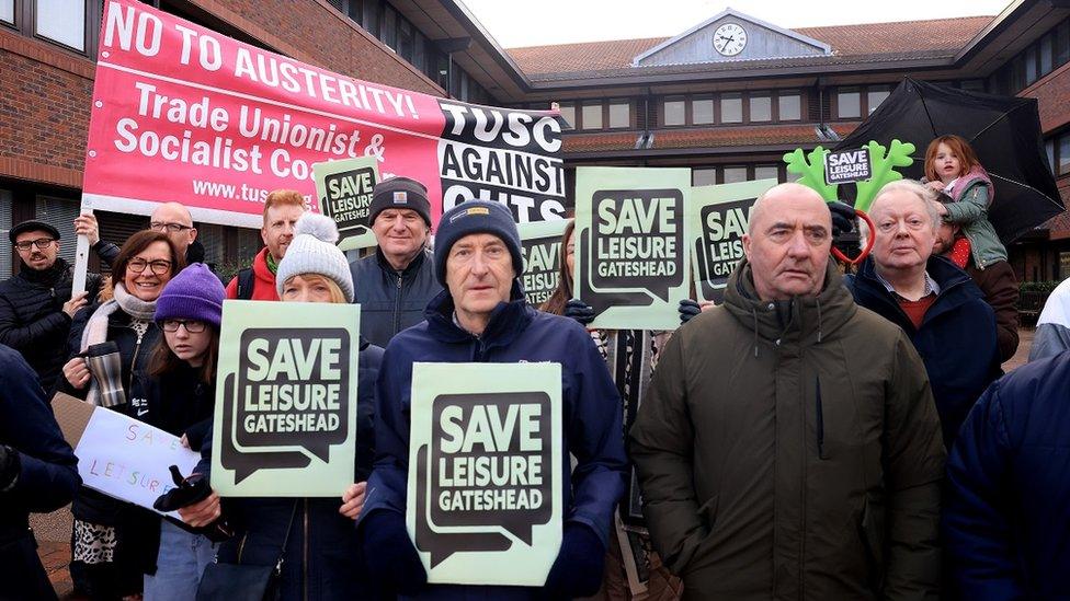 Protesters carrying banners calling for a rethink over closure plans