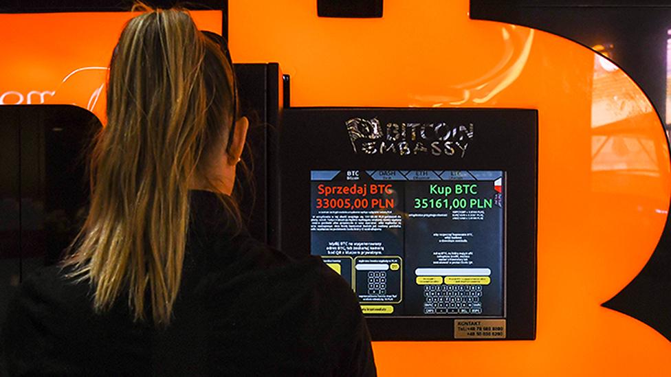 A woman using a machine to purchase Bitcoin