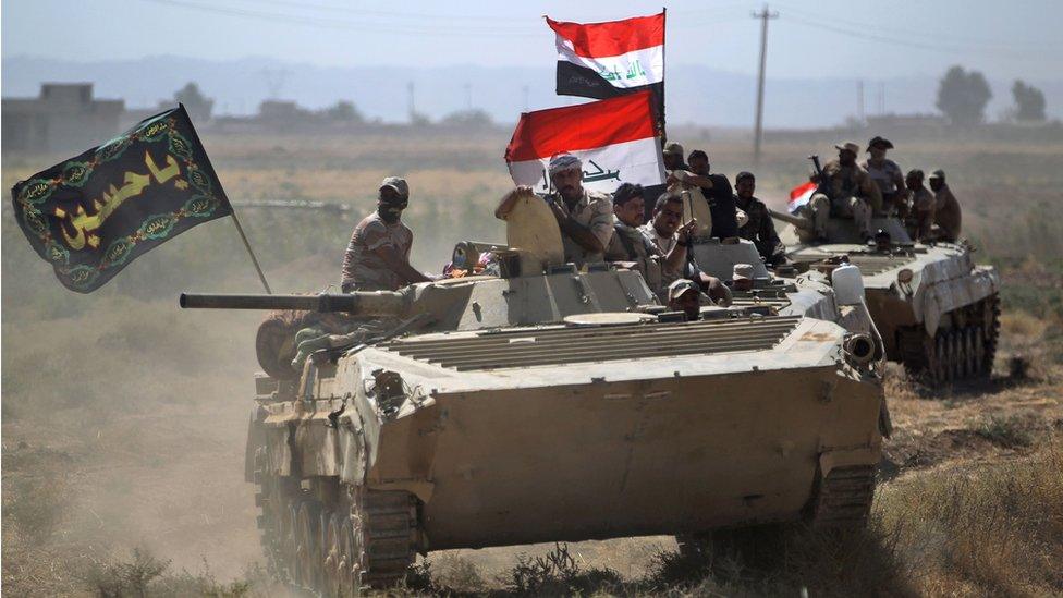 men in tank with flags