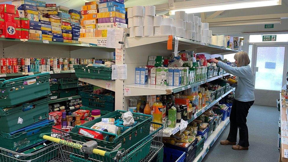 A volunteer stacking shelves