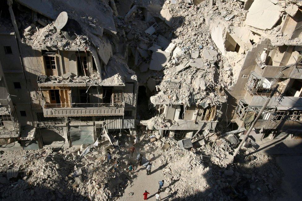 People search for survivors at the site of a reported air strike Tariq al-Bab, Aleppo, Syria on 26 September 2016