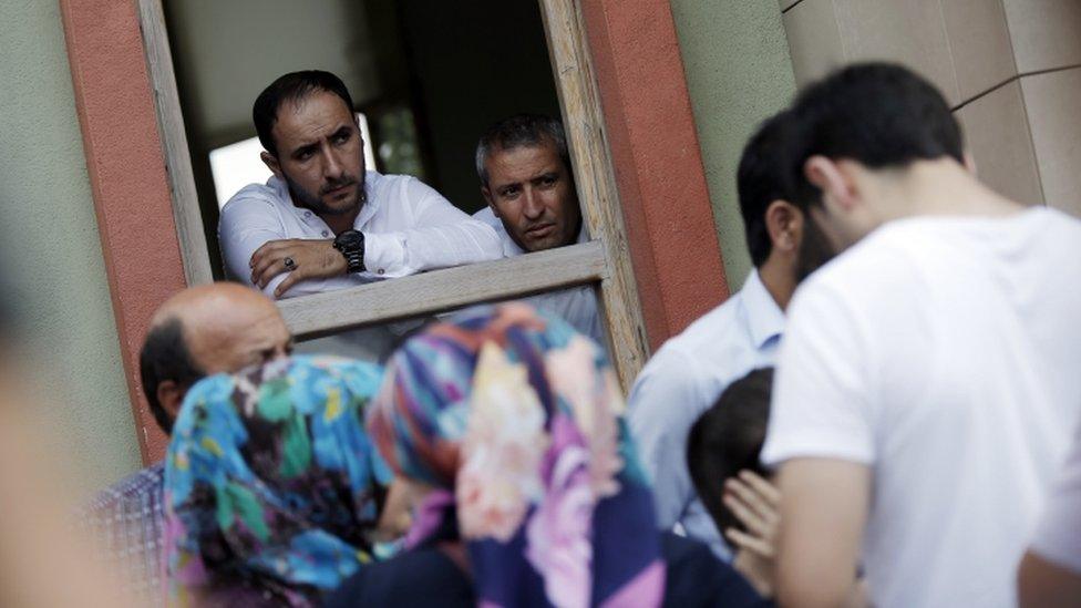 Forensic Medical Centre officials look out on family members who had gathered to hear news