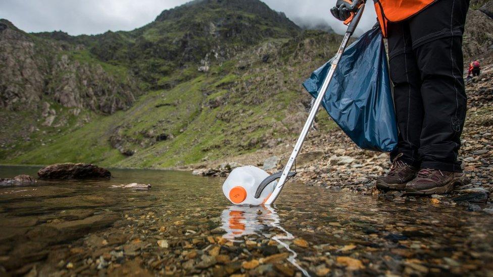 A milk bottle being picked up by a litter picker