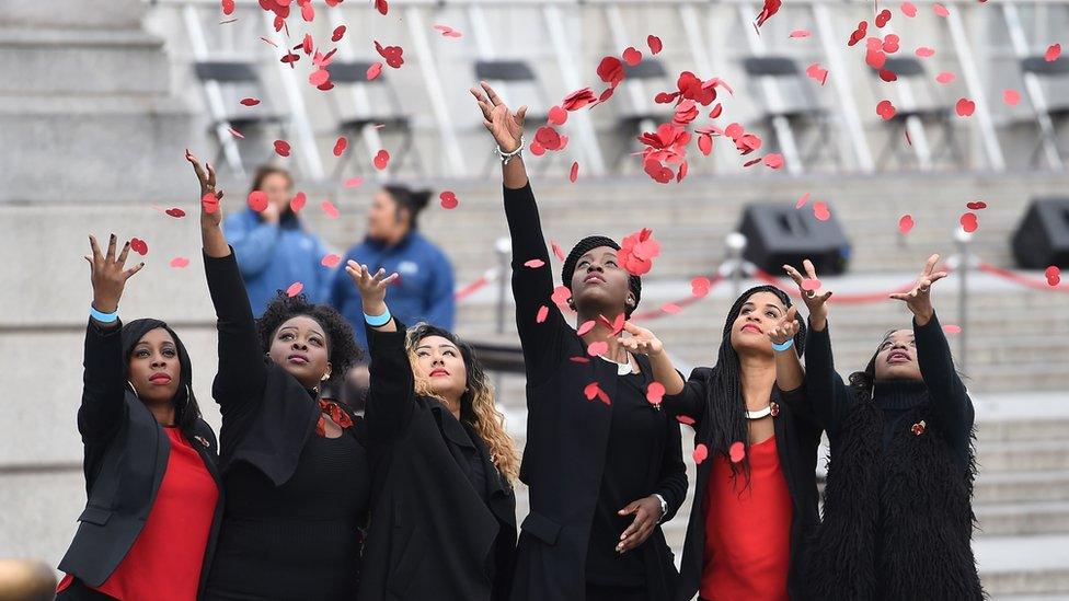 Members of London Community Gospel Choir throw poppies in Trafalgar Square, London, on 11 November 2015