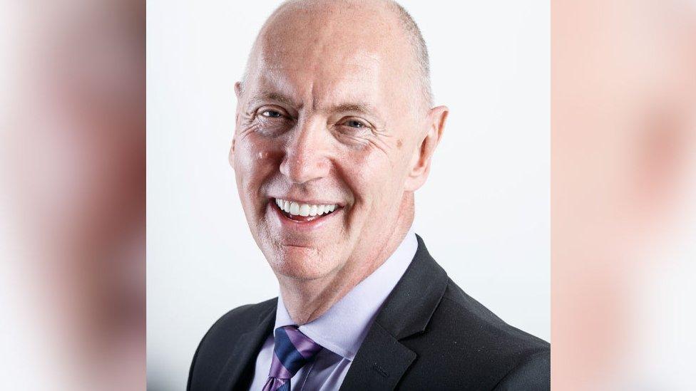 A company head and shoulders portrait photo of Mr Barrow who is smiling at the camera against a white background