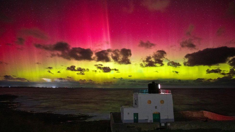 Pink and yellow hues lit up skies over Bamburgh lighthouse