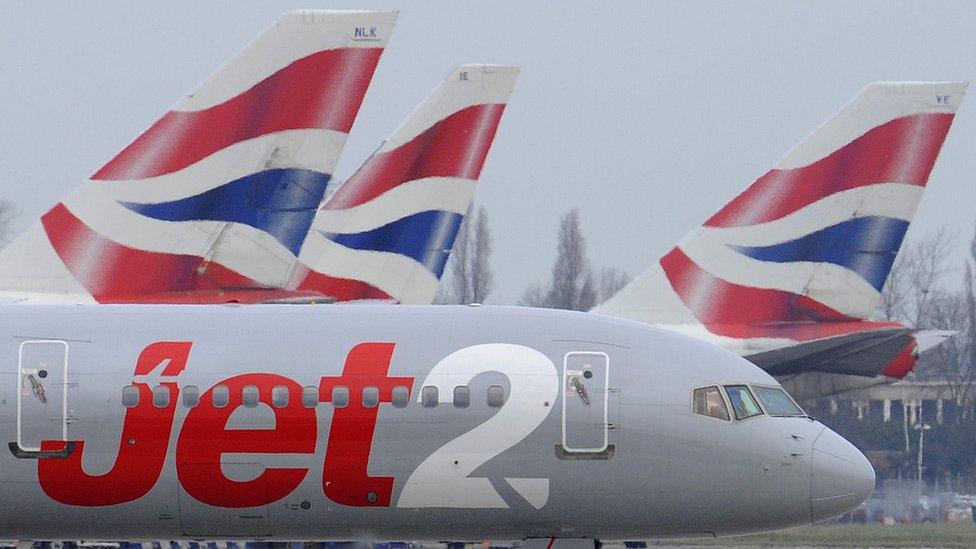 A Jet2 aircraft taxis past British Airways aircraft at Heathrow Airport in London.