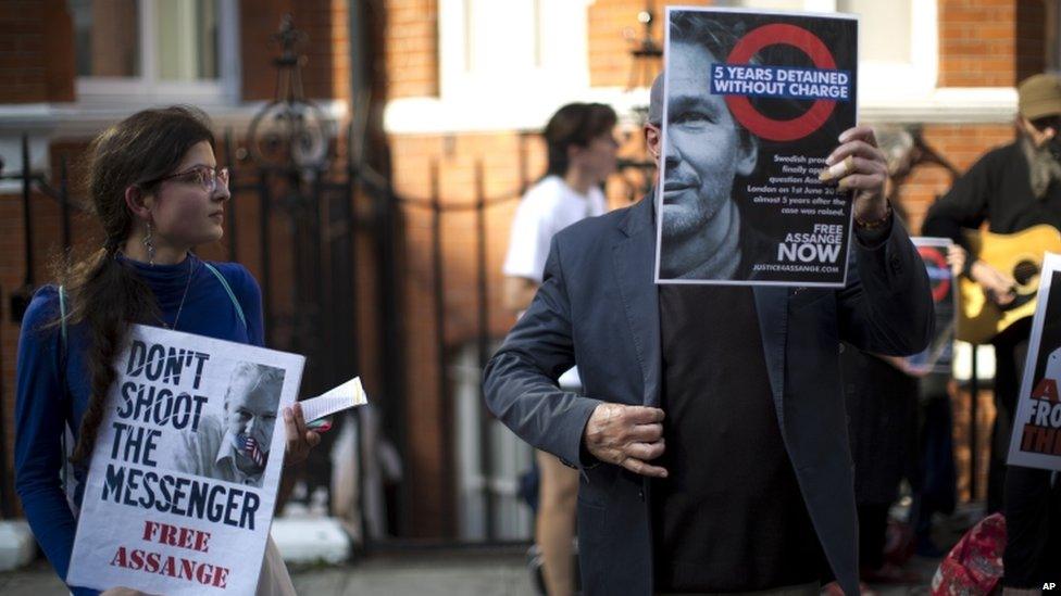 Supporters of WikiLeaks founder Julian Assange hold placards during a vigil across the street from the Ecuador embassy in London, Friday 19, June 2015