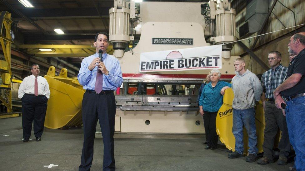 Wisconsin Gov. Scott Walker (2nd L) speaks as New Jersey Gov. Chris Christie (L) listens during a campaign stop at Empire Bucket, a manufacturing facility September 29, 2014 in Hudson, Wisconsin.