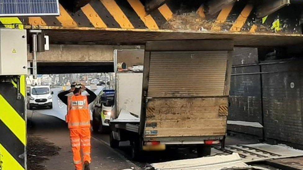 Van stuck under bridge