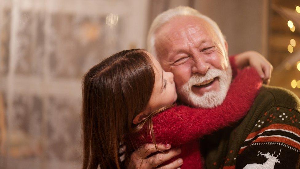 Little girl hugging and kissing an older man